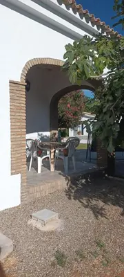 a patio with a table and two zebras under an arch at Chalet casa la adelfa in Chiclana de la Frontera