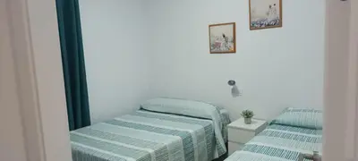 two twin beds in a room with a mirror at Chalet casa la adelfa in Chiclana de la Frontera