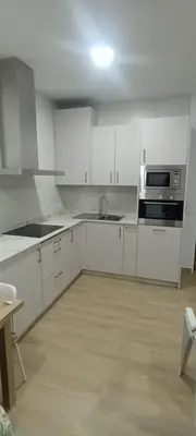 a kitchen with white cabinets and a sink and a stove at Chalet casa la adelfa in Chiclana de la Frontera