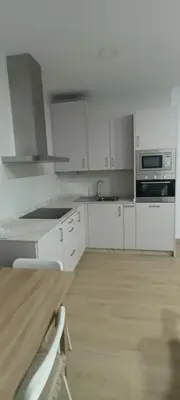 a kitchen with white cabinets and a stove top oven at Chalet casa la adelfa in Chiclana de la Frontera