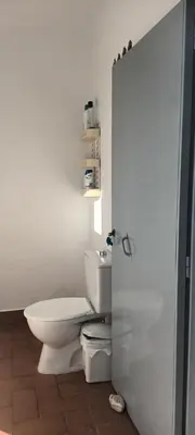 a white bathroom with a toilet and a sink at Chalet casa la adelfa in Chiclana de la Frontera