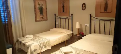 a bedroom with two beds and a lamp at Mis Tres Centenarios in El Puerto de Santa María
