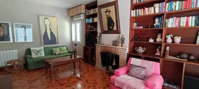 a living room with pink chairs and bookshelves at Mis Tres Centenarios in El Puerto de Santa María