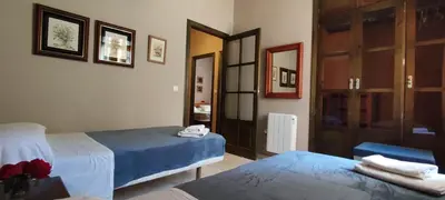 a bedroom with two beds and a door with towels at Mis Tres Centenarios in El Puerto de Santa María