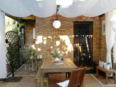 a patio with a wooden table in front of a brick wall at Mis Tres Centenarios in El Puerto de Santa María
