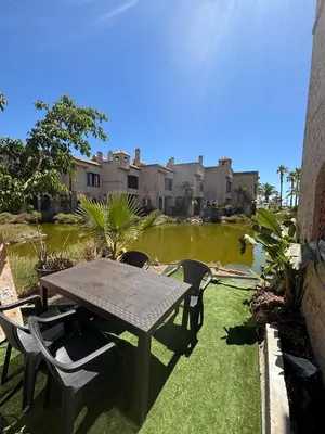 a patio with a table and chairs and a pond at Bungalow Bahia Sur 33 in San Fernando