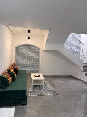 a living room with a green couch and a table at Bungalow Bahia Sur 33 in San Fernando