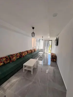 a living room with a green couch and a table at Bungalow Bahia Sur 33 in San Fernando