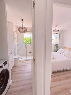 a white bedroom with a bed and a bathroom at Sibs Sanlucar - casita playa - coqueto vistas in Sanlúcar de Barrameda