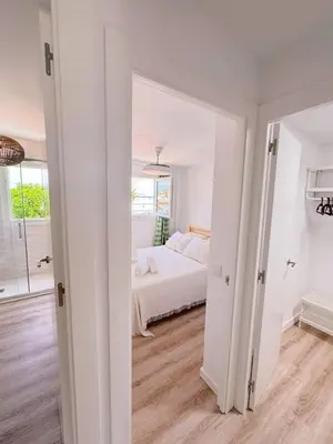 a white bedroom with a bed and a window at Sibs Sanlucar - casita playa - coqueto vistas in Sanlúcar de Barrameda