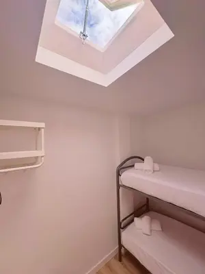 a dorm room with a skylight and bunk beds at Sibs Sanlucar - casita playa - coqueto vistas in Sanlúcar de Barrameda