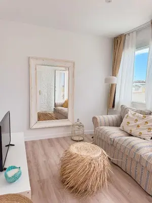 a living room with a couch and a mirror at Sibs Sanlucar - casita playa - coqueto vistas in Sanlúcar de Barrameda