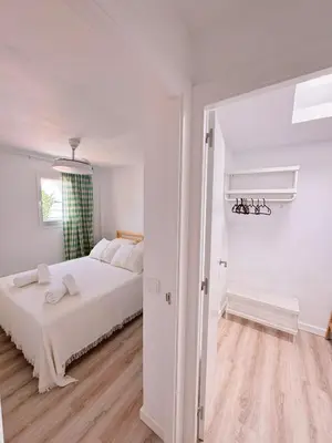 a white bedroom with a bed and a window at Sibs Sanlucar - casita playa - coqueto vistas in Sanlúcar de Barrameda