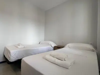 two beds in a room with towels on them at Apartoyou Nuevo Puerto Sherry in El Puerto de Santa María