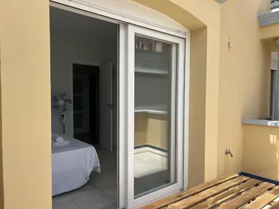 a sliding glass door leading to a room with a bed at Apartoyou Nuevo Puerto Sherry in El Puerto de Santa María