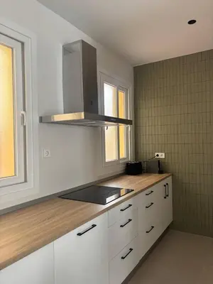 a kitchen with white cabinets and a stove top at Casa Keito, Playa y Patio in Cádiz