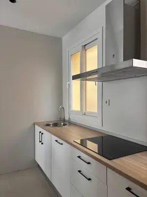 a kitchen with white cabinets and a sink at Casa Keito, Playa y Patio in Cádiz