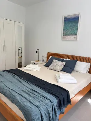 a bedroom with a large bed with a blue blanket at Casa Keito, Playa y Patio in Cádiz