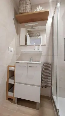 a bathroom with a sink and a mirror at Apartamento Sotavento - 2 dormitorios in Chipiona