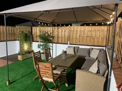 a patio with a table and chairs under a tent at Apartamento Sotavento - 2 dormitorios in Chipiona