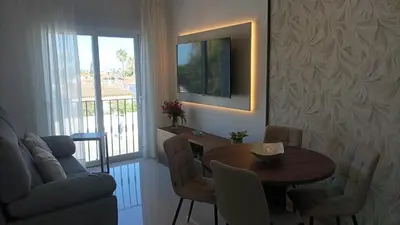 a living room with a dining room table and a couch at Chiclana Apartamento zona playa in Chiclana de la Frontera