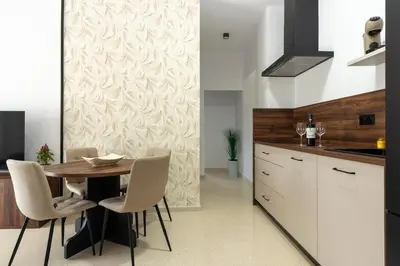 a kitchen with a wooden table and white chairs at Chiclana Apartamento zona playa in Chiclana de la Frontera