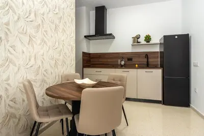 a dining room with a table and chairs and a kitchen at Chiclana Apartamento zona playa in Chiclana de la Frontera