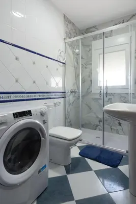 a bathroom with a washing machine and a toilet at Chiclana Apartamento zona playa in Chiclana de la Frontera
