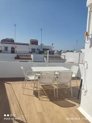 a table and chairs on the balcony of a ship at Mi Rinconcito in Chipiona