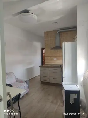 a kitchen with a refrigerator and a table in a room at Mi Rinconcito in Chipiona