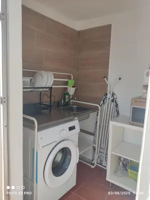 a laundry room with a washing machine and a sink at Mi Rinconcito in Chipiona