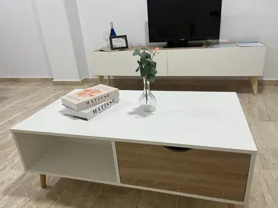 a white coffee table with two books and a vase with flowers at Apartamento Taymar Daniel in Chiclana de la Frontera