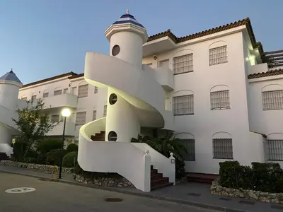 a building with a spiral staircase in front of it at Apartamento Taymar Daniel in Chiclana de la Frontera