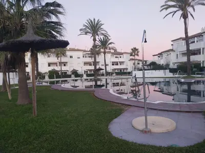 a resort with a park with palm trees and a playground at Apartamento Taymar Daniel in Chiclana de la Frontera
