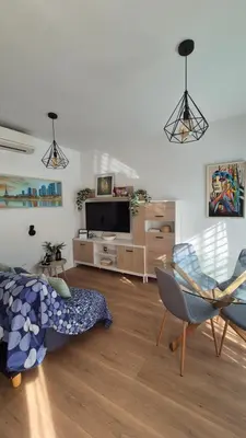 a living room with a couch and chairs and a television at Apartamento Colegueo in Sanlúcar de Barrameda