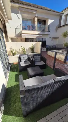 a yard with couches and chairs in front of a house at Apartamento Colegueo in Sanlúcar de Barrameda