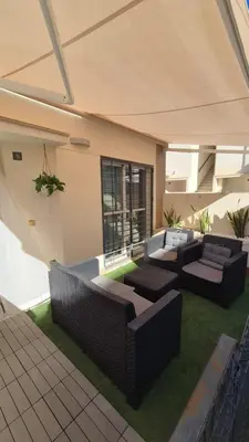 a living room with couches and chairs on grass at Apartamento Colegueo in Sanlúcar de Barrameda