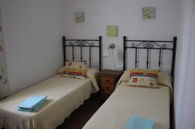 two beds sitting next to each other in a bedroom at Chalet con piscina privada en Conil in Cádiz