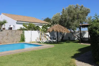 a yard with a swimming pool and a house at Chalet con piscina privada en Conil in Cádiz