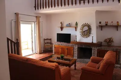 a living room with a couch and a fireplace at Chalet con piscina privada en Conil in Cádiz