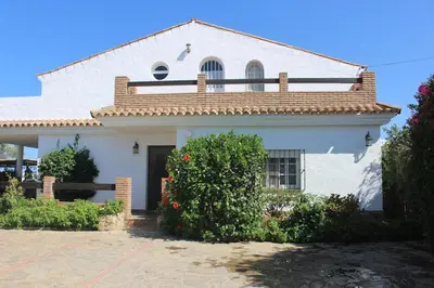 a white house with a roof at Chalet con piscina privada en Conil in Cádiz
