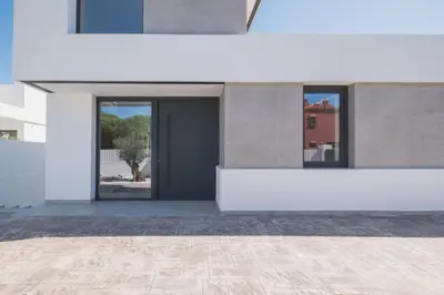 a white building with a door and a courtyard at Increíble Villa en campo de golf in Novo Sancti Petri