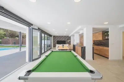 a pool table in the middle of a living room at Increíble Villa en campo de golf in Novo Sancti Petri
