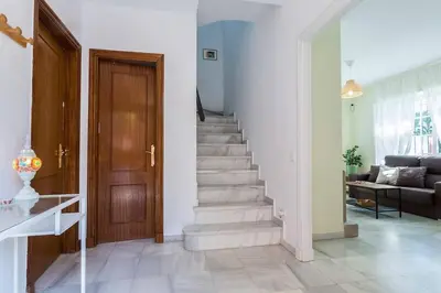 a staircase in a living room with a wooden door at Playa de fuentebravía in El Puerto de Santa María