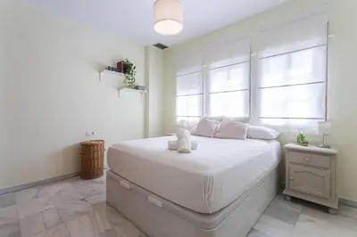 a bedroom with a white bed with a teddy bear on it at Playa de fuentebravía in El Puerto de Santa María