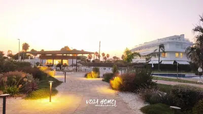 a resort with a building and a courtyard with flowers at Apartamento Eleven View Costa ballena MOON BLACK in Costa Ballena