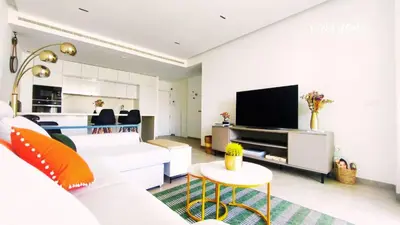 a living room with a white couch and a tv at Apartamento Eleven View Costa ballena MOON BLACK in Costa Ballena