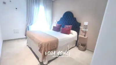 a bedroom with a large bed with a blue headboard at Apartamento Eleven View Costa ballena MOON BLACK in Costa Ballena