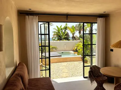 a living room with a large sliding glass door to a pool at Luxury Beach Front Boutique Hideaway with Pool - Casita Mas Tranquila in Conil de la Frontera