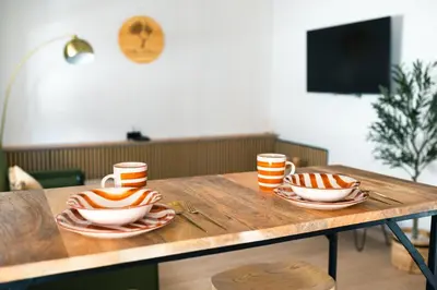 a wooden table with two cups and plates on it at El Olivar de Baro in Jerez de la Frontera